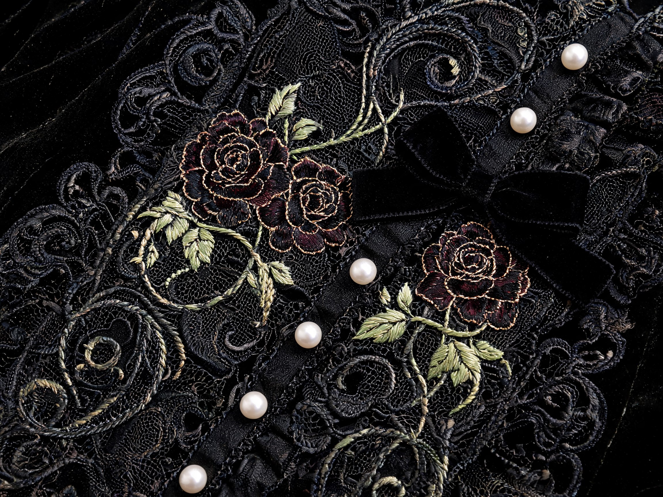 Dettaglio decorativo gothic lolita con pizzo nero, rose scure e ornamenti in stile Art Nouveau botanico