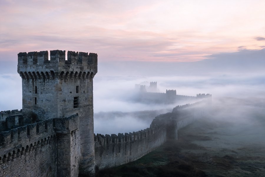 Le torri medievali di Carcassonne all'alba con la nebbia del Languadoca: le mura difensive visigote e capetinge