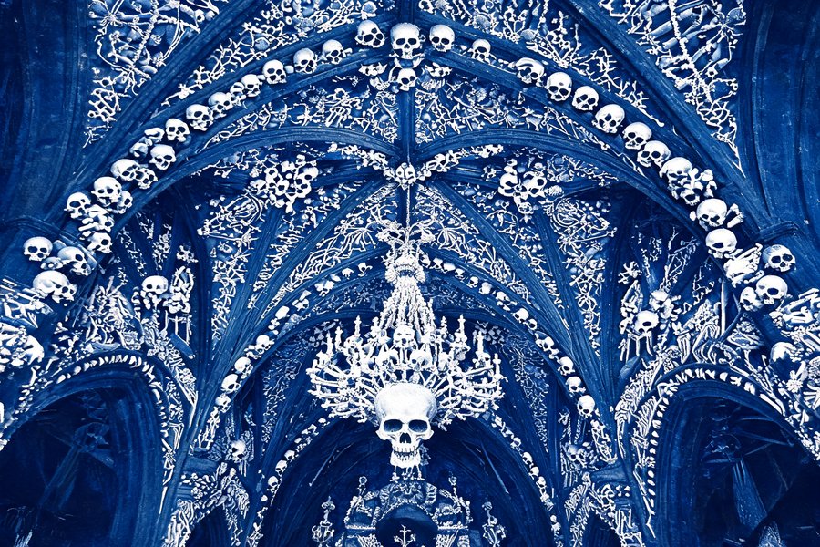 L'interno della Sedlec Ossuary di Kutná Hora: la volta gotica decorata con 40.000 crani e ossa umane disposte in motivi ornamentali