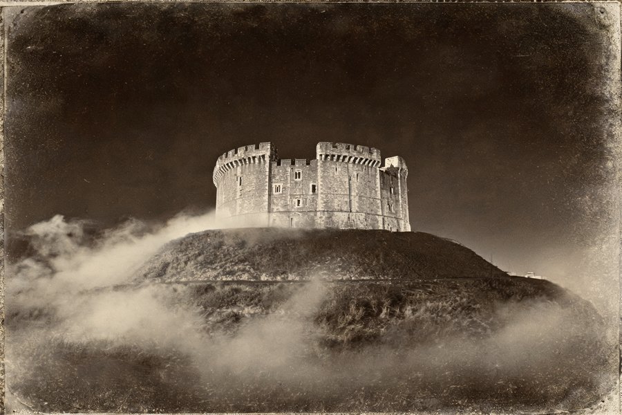 La Clifford's Tower di York di notte avvolta nella nebbia: il dongione normanno teatro del massacro degli ebrei del 1190